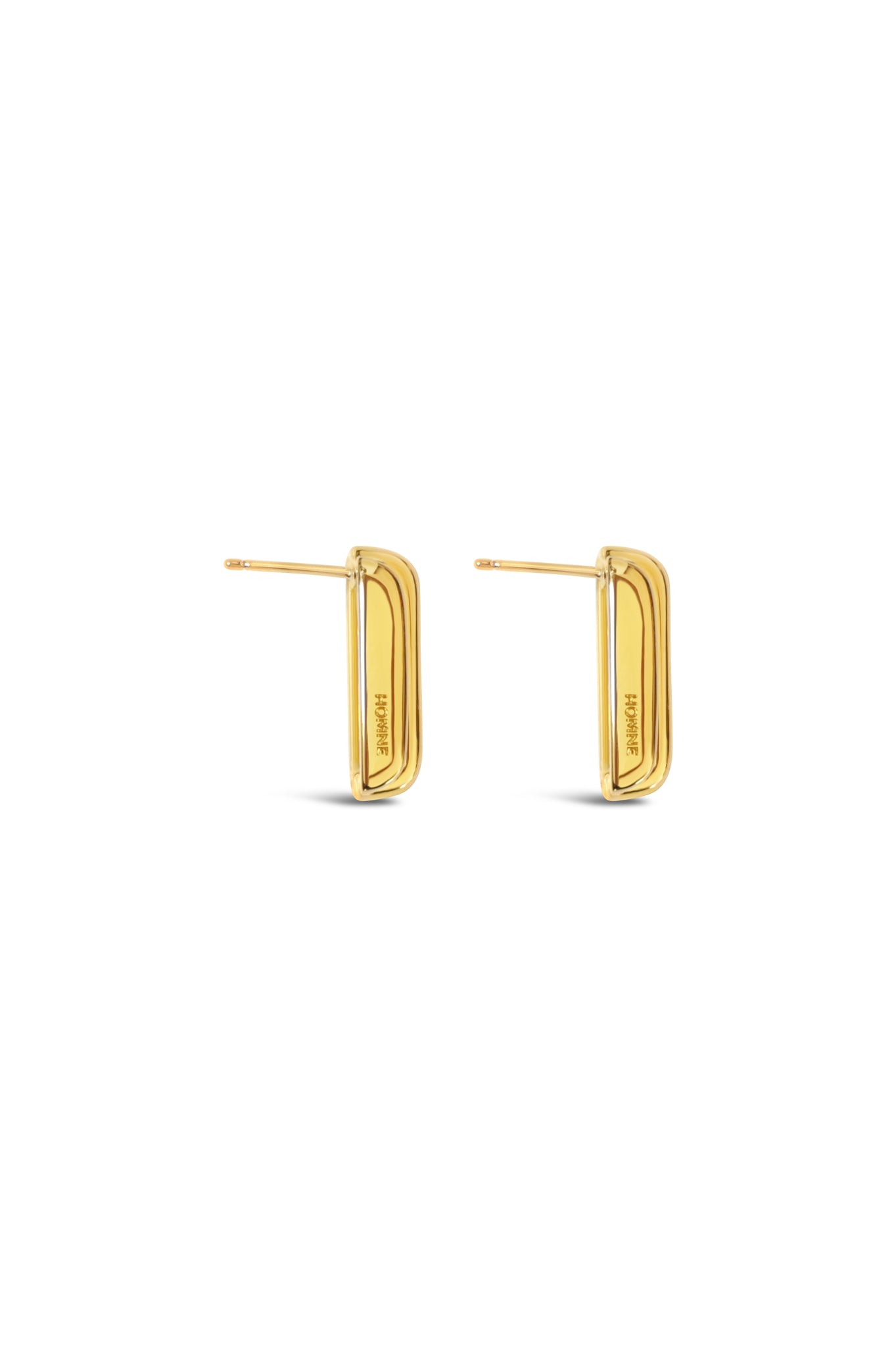 side view of gold earrings on a white background
