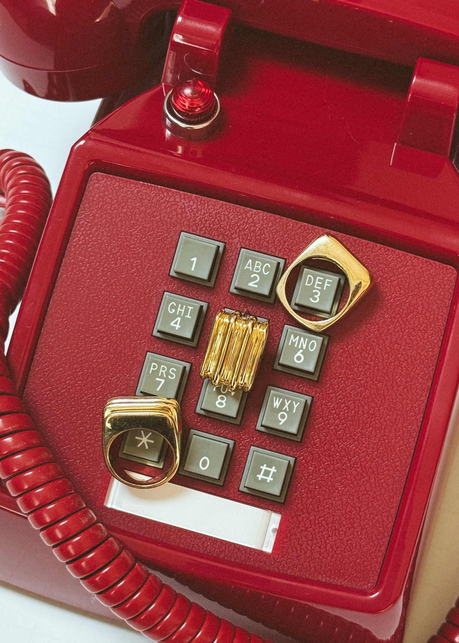 Red vintage-style telephone with gold accents on a white background